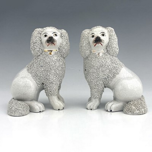 1045 - A Staffordshire matching pair of poodles, circa 1860, seated figures modelled as part-shaved poodles... 