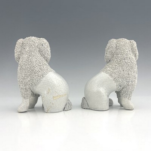 1045 - A Staffordshire matching pair of poodles, circa 1860, seated figures modelled as part-shaved poodles... 