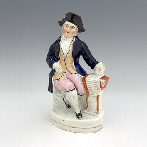 1050 - A Staffordshire figure, circa 1850, modelled seated in cobalt blue coat and tricorn hat, his left ha... 