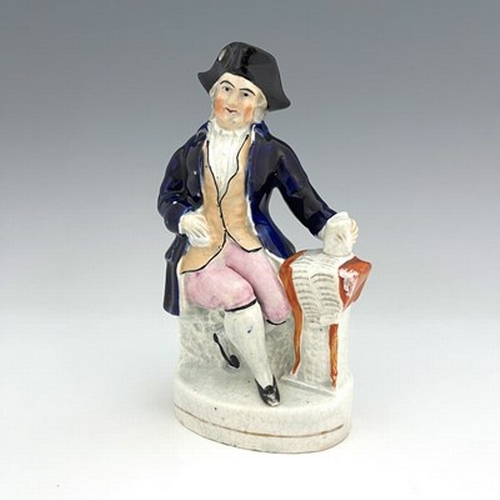 1050 - A Staffordshire figure, circa 1850, modelled seated in cobalt blue coat and tricorn hat, his left ha... 