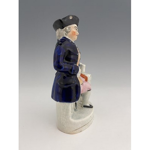 1050 - A Staffordshire figure, circa 1850, modelled seated in cobalt blue coat and tricorn hat, his left ha... 