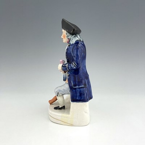 1060 - A Staffordshire figure of a Greenwich Hospital pensioner, circa 1850, modelled as a seated sailor wi... 