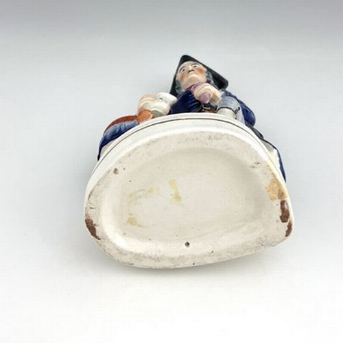 1060 - A Staffordshire figure of a Greenwich Hospital pensioner, circa 1850, modelled as a seated sailor wi... 