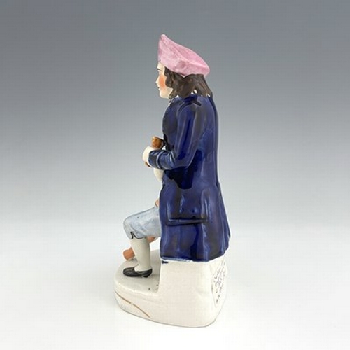 1061 - A Staffordshire figure of a Greenwich Hospital pensioner, circa 1850, modelled as a seated sailor wi... 