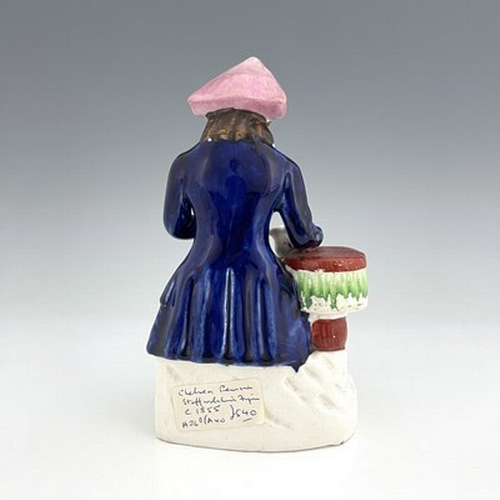 1061 - A Staffordshire figure of a Greenwich Hospital pensioner, circa 1850, modelled as a seated sailor wi... 