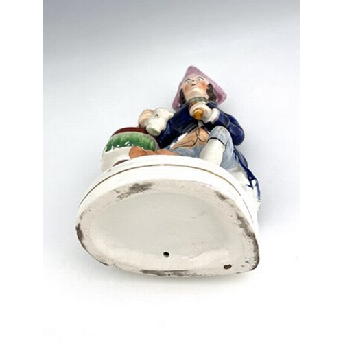 1061 - A Staffordshire figure of a Greenwich Hospital pensioner, circa 1850, modelled as a seated sailor wi... 