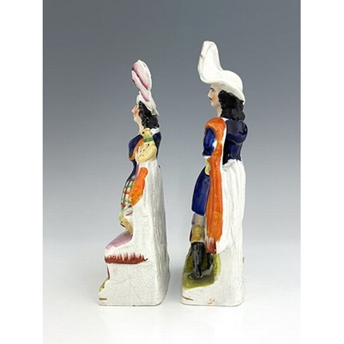 1069 - A pair of Staffordshire pottery figures, circa 1860, modelled as ornately dressed male and female fi... 