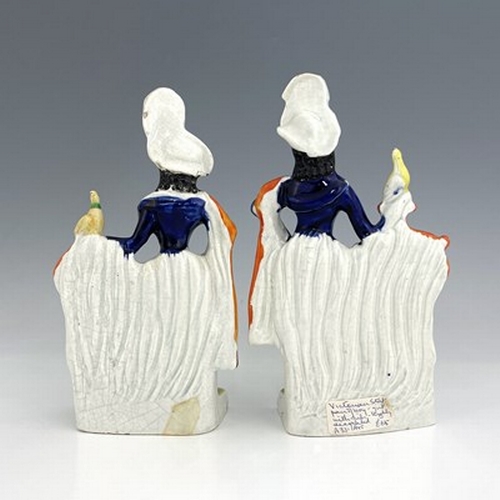 1069 - A pair of Staffordshire pottery figures, circa 1860, modelled as ornately dressed male and female fi... 