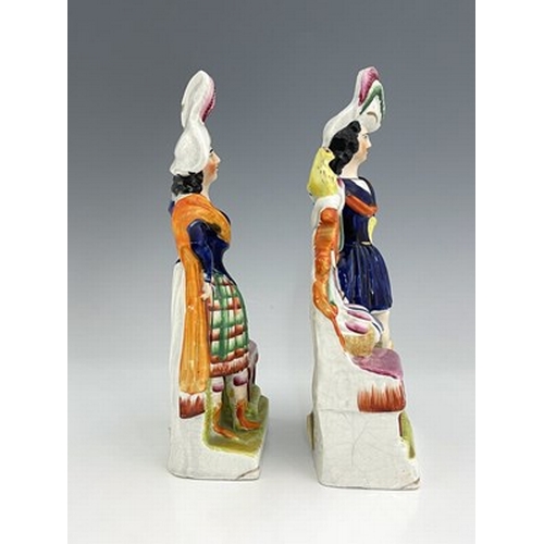 1069 - A pair of Staffordshire pottery figures, circa 1860, modelled as ornately dressed male and female fi... 