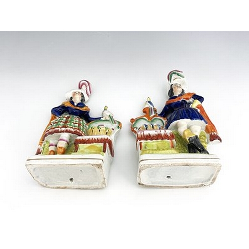 1069 - A pair of Staffordshire pottery figures, circa 1860, modelled as ornately dressed male and female fi... 