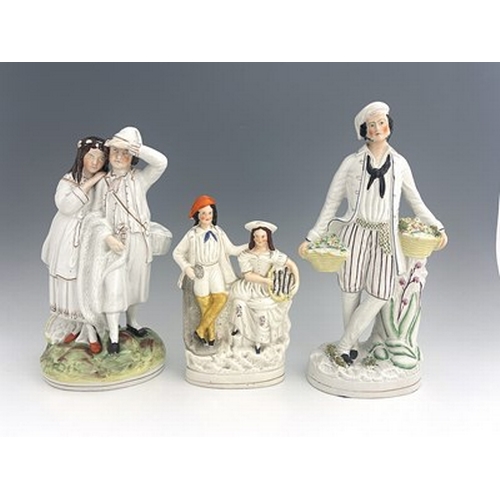 1071 - Three Staffordshire figure groups , circa 1865, one modelled as a standing male fruitseller in white... 