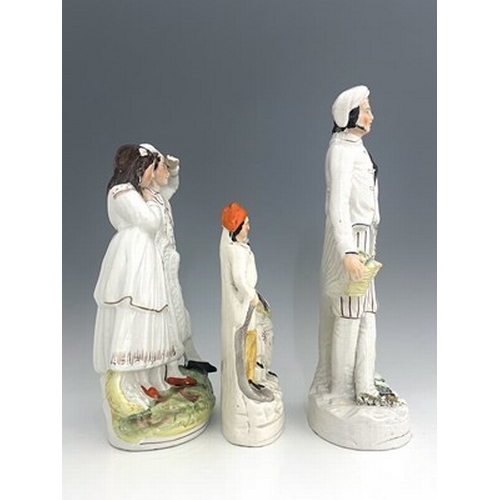 1071 - Three Staffordshire figure groups , circa 1865, one modelled as a standing male fruitseller in white... 