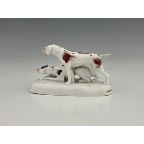 1076 - A Staffordshire porcelain figure group of two hounds, circa 1835, on oval base with gilt line decora... 