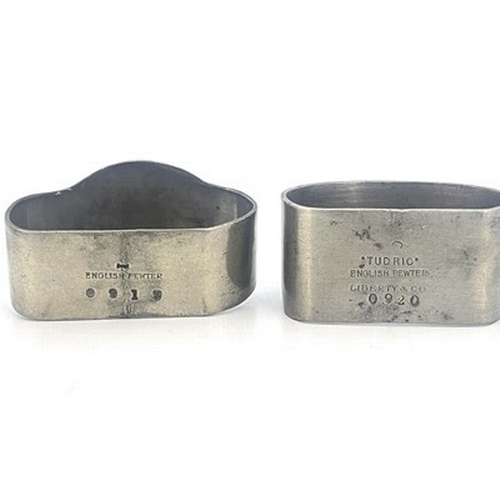 139 - Archibald Knox for Liberty and Co., two Tudric Arts and Crafts pewter napkin rings, one with enamell... 