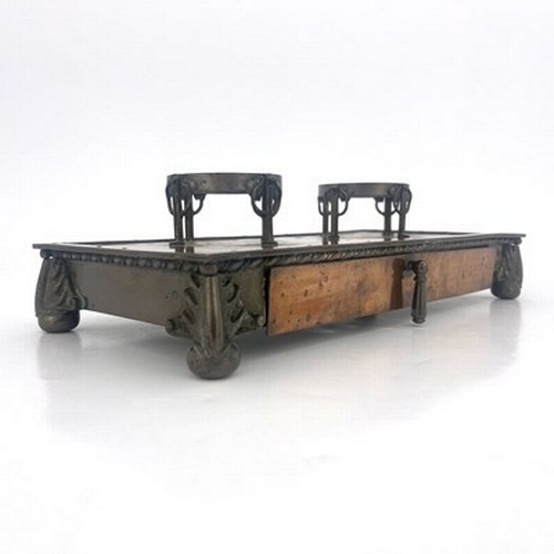 143 - Frederick Shields, an Arts and Crafts patinated copper double inkwell, platform form with two open s... 