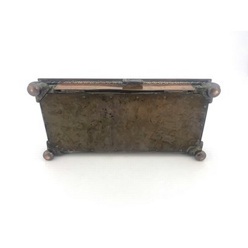 143 - Frederick Shields, an Arts and Crafts patinated copper double inkwell, platform form with two open s... 