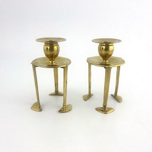 150 - A pair of Arts and Crafts brass candlesticks, in the style of C F A Voysey, 1906, each with three ve... 