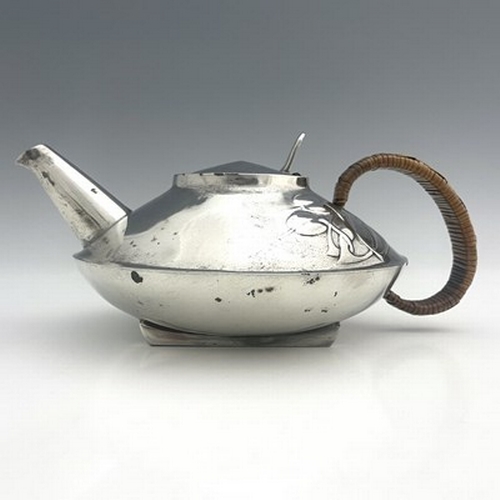 153 - Archibald Knox for Liberty and Co., a Tudric pewter teapot, 0231, squat form with rattan handle and ... 