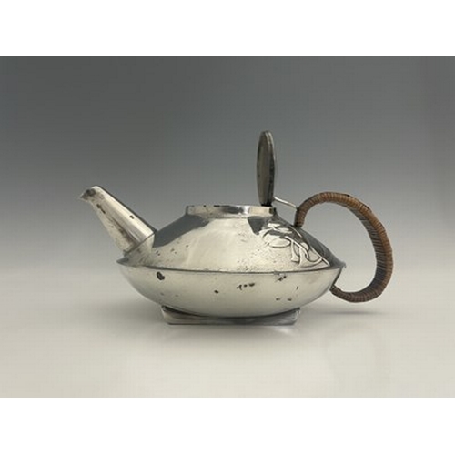 153 - Archibald Knox for Liberty and Co., a Tudric pewter teapot, 0231, squat form with rattan handle and ... 