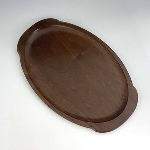 177 - Stanley Webb Davies, an Arts and Crafts carved walnut tray, 1945, twin handled oval form, with chain... 