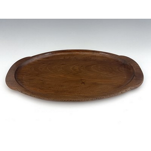 177 - Stanley Webb Davies, an Arts and Crafts carved walnut tray, 1945, twin handled oval form, with chain... 