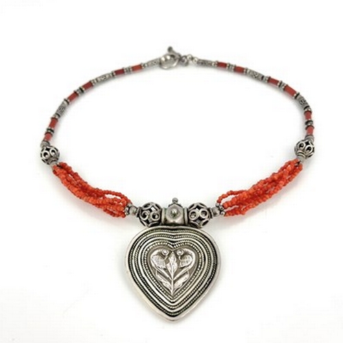 25 - A silver and coral necklace, possibly Central American, the heart shaped pendant of concentric ropet... 