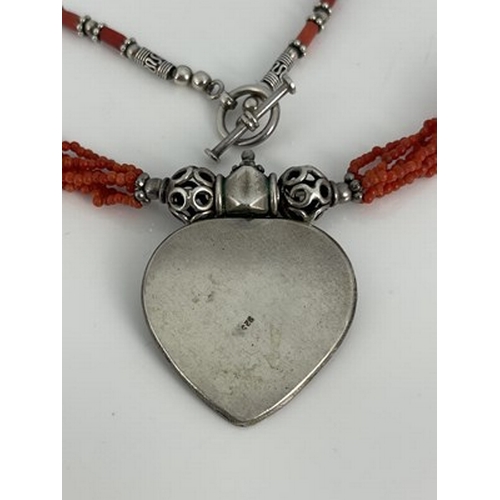 25 - A silver and coral necklace, possibly Central American, the heart shaped pendant of concentric ropet... 