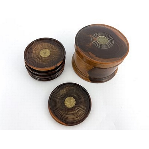 260 - A set of six lignum vitae turned coasters, in associated cylinder box, each piece set with a predomi... 