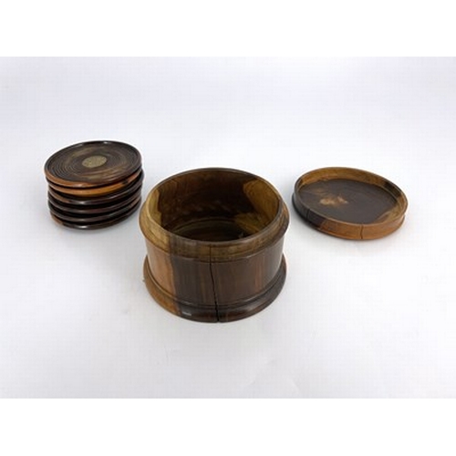 260 - A set of six lignum vitae turned coasters, in associated cylinder box, each piece set with a predomi... 