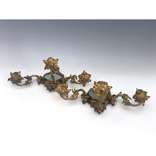 289 - A pair of gilt metal girandoles, late 19th Century, of Rococo design, circular looking glasses, trip... 