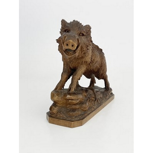 298 - A Black Forest carved wood figure of a boar, 19th century, realistically modelled on a rocky outcrop... 