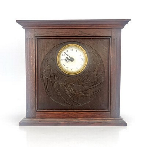 552 - An Arts and Crafts Glasgow School carved oak clock, cuboid form with fluted columns flanking a relie... 