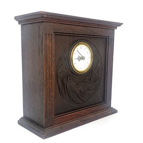 552 - An Arts and Crafts Glasgow School carved oak clock, cuboid form with fluted columns flanking a relie... 