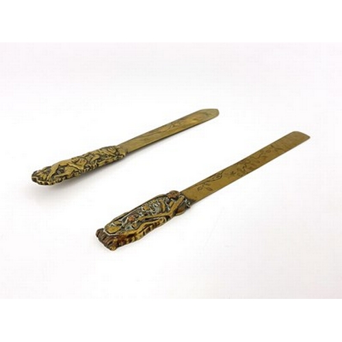 566 - Two Japanese brass and mixed metal page turners, the blades engraved with naturalistic floral branch... 