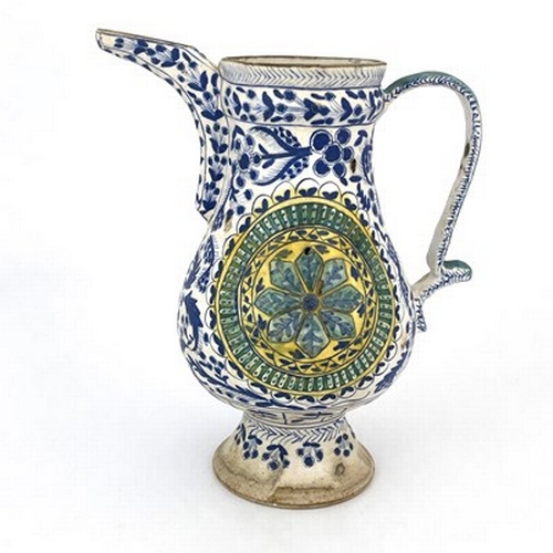 569 - A Turkish Ottoman pottery ewer, footed baluster form, relief moulded floral roundels within blue and... 