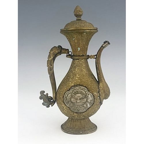 586 - A Persian white metal and brass ewer, embossed and chased in relief with foliate scroll design