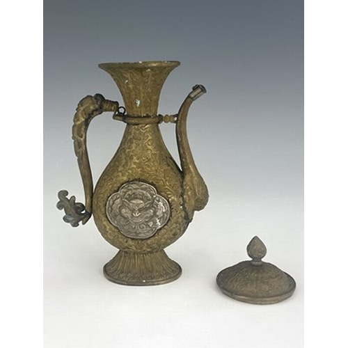 586 - A Persian white metal and brass ewer, embossed and chased in relief with foliate scroll design