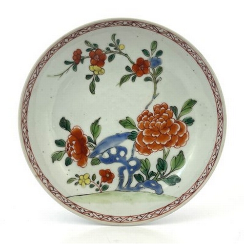 604 - A Chinese famille rose dish or large saucer, 18th century, painted and enamelled with peony and root... 