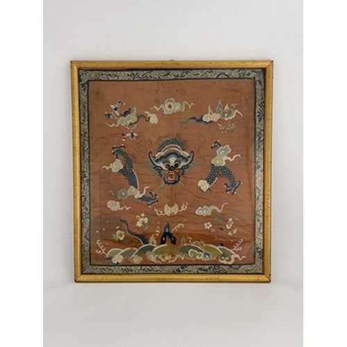 617 - A Chinese silk embroidered panel, decorated with dragon amongst clouds, on rust coloured ground, 65c... 