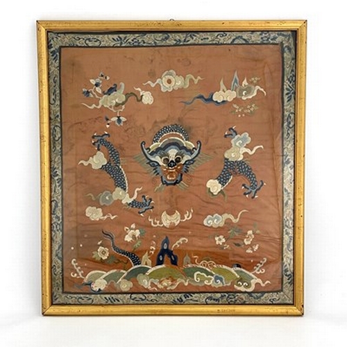 617 - A Chinese silk embroidered panel, decorated with dragon amongst clouds, on rust coloured ground, 65c... 