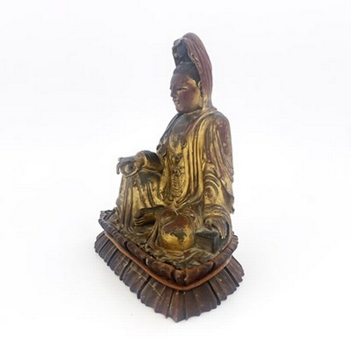 619 - A Chinese carved giltwood figure of Guanyin, modelled in Royal Ease pose, one hand resting on a rais... 