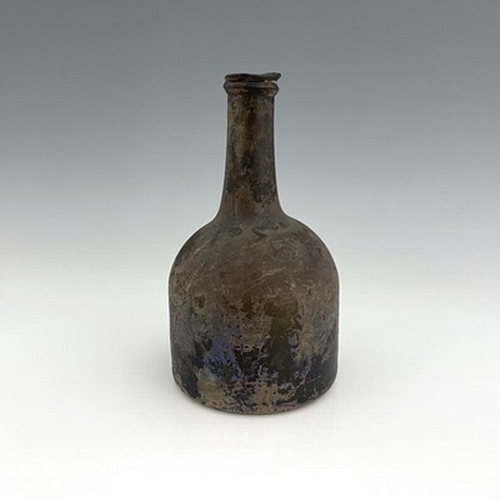 648 - An early 18th century glass wine bottle, squat mallet form, oxidised patination, 21cm high