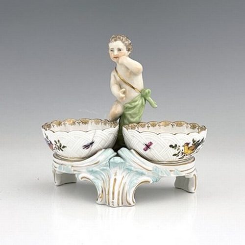 794 - A Berlin porcelain figural double salt cellar, 19th century, the central putto between two basket mo... 