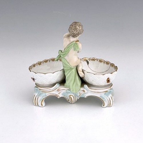 794 - A Berlin porcelain figural double salt cellar, 19th century, the central putto between two basket mo... 