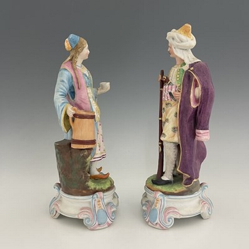 804 - A pair of bisque figures, 19th century, modelled as a Turkish soldier and woman, 28cm high (2)