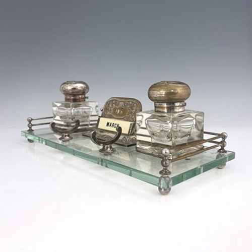 82 - An Art Nouveau silver plated and glass desk stand, probably American, the rectangular glass platform... 