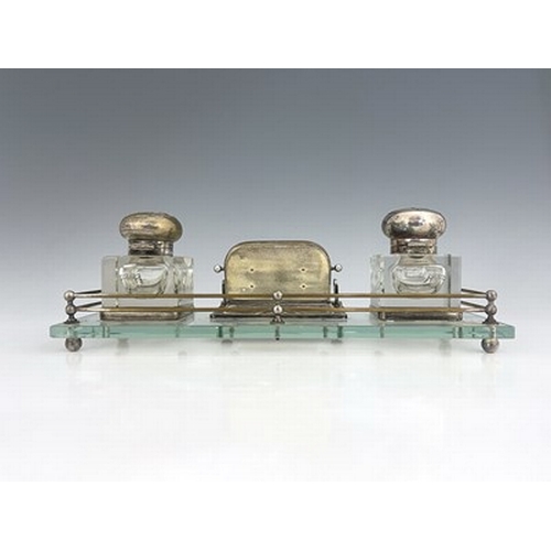 82 - An Art Nouveau silver plated and glass desk stand, probably American, the rectangular glass platform... 