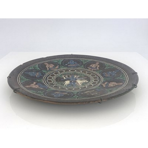 822 - Bombay School of Art, an art pottery charger, slip decorated with a central Hindu scene within round... 