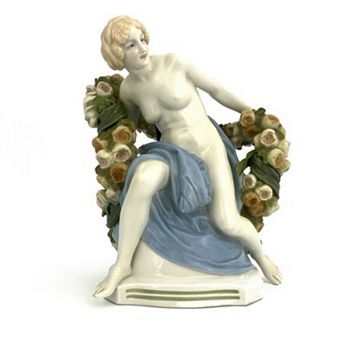 827 - Paul Schley for KPM, an Art Deco female nude figure, modelled seated with a garland of roses, impres... 