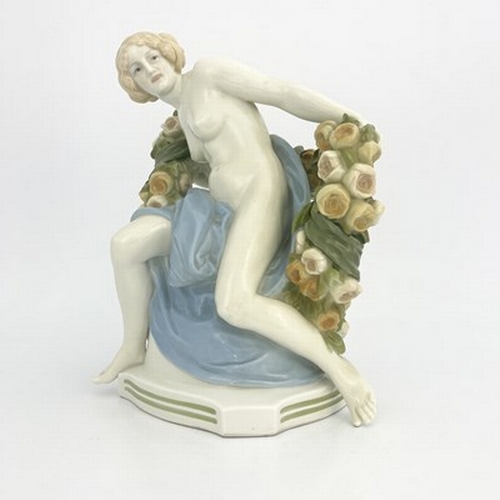 827 - Paul Schley for KPM, an Art Deco female nude figure, modelled seated with a garland of roses, impres... 